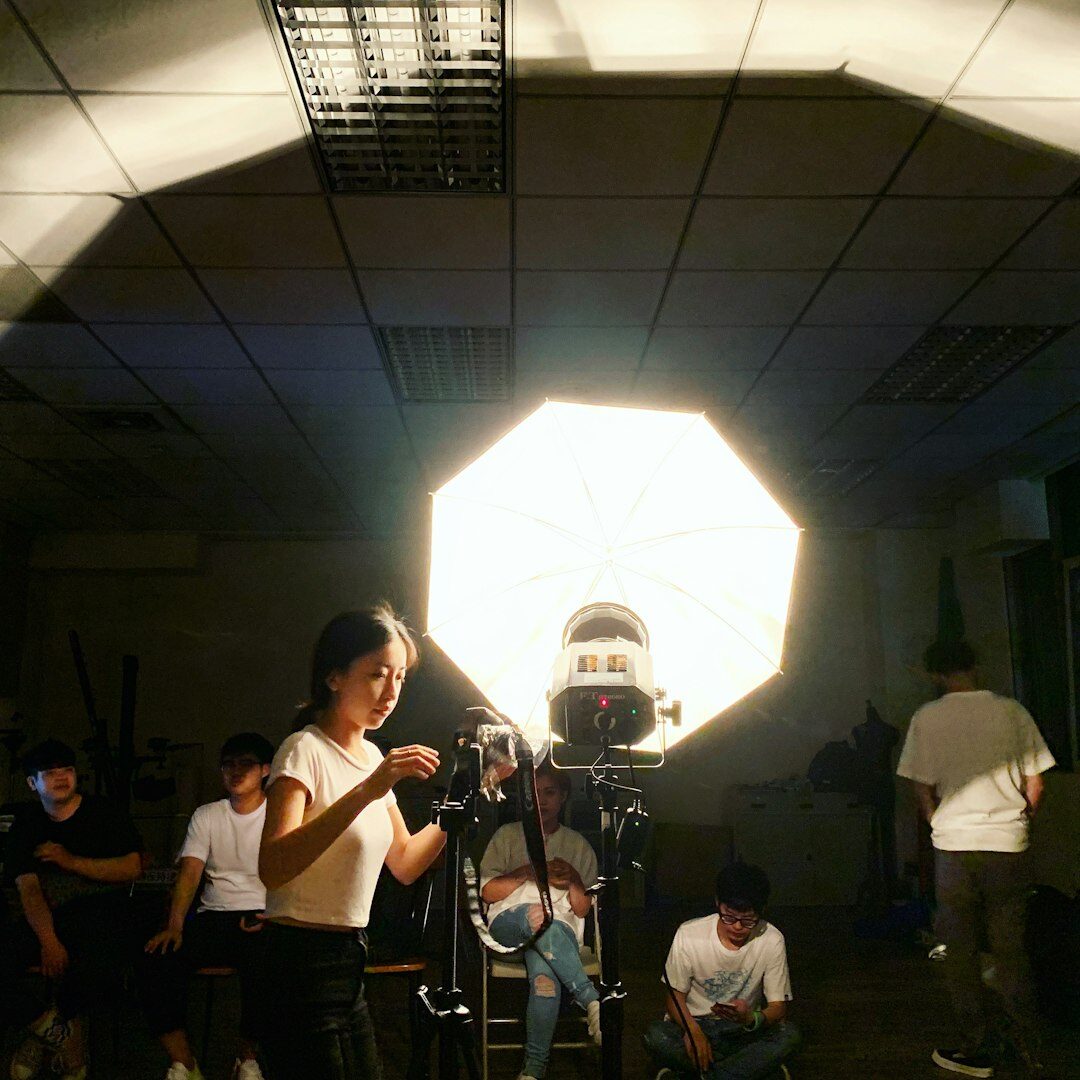 Small film crew setting up a camera and light on set